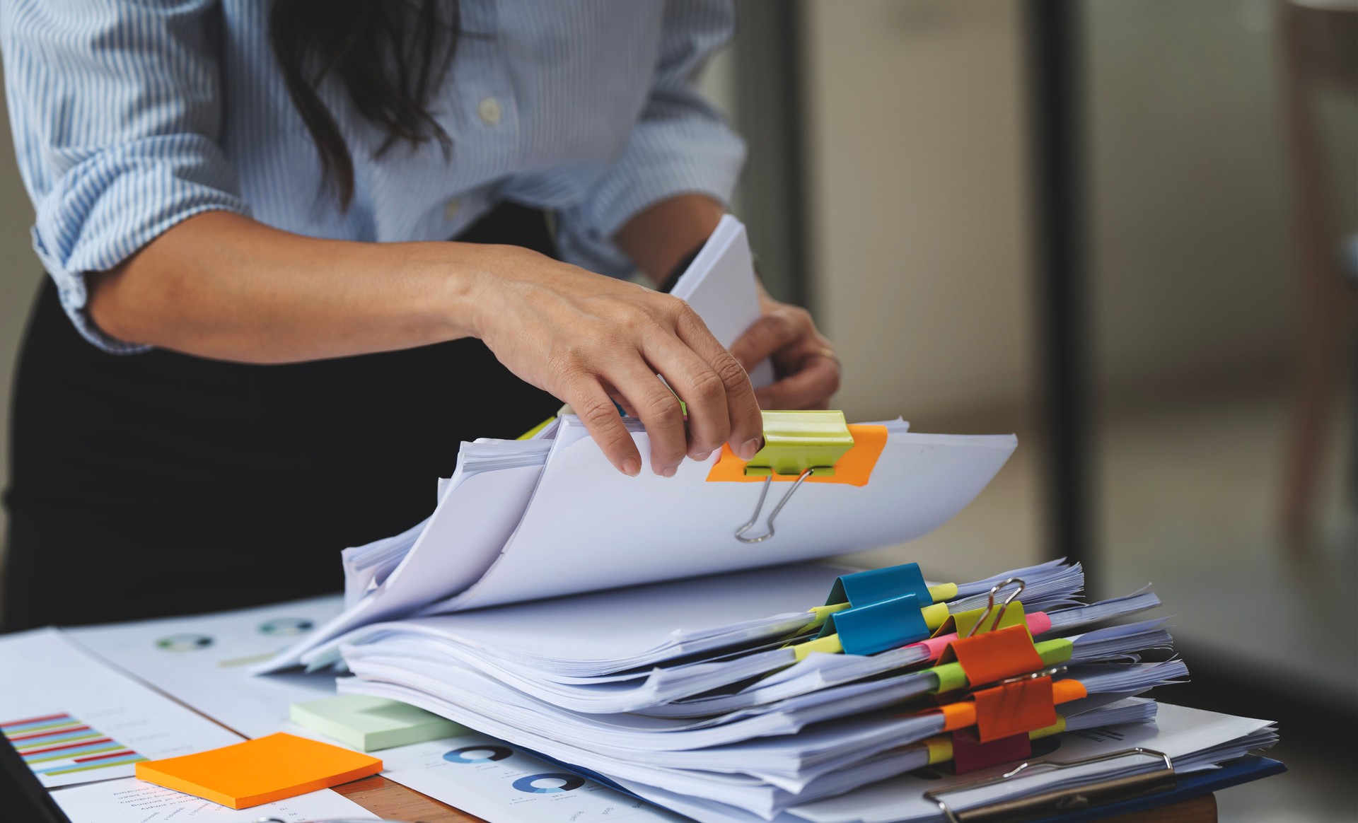 Businesswoman organizing nonprofit compliance documents and verifying filing records