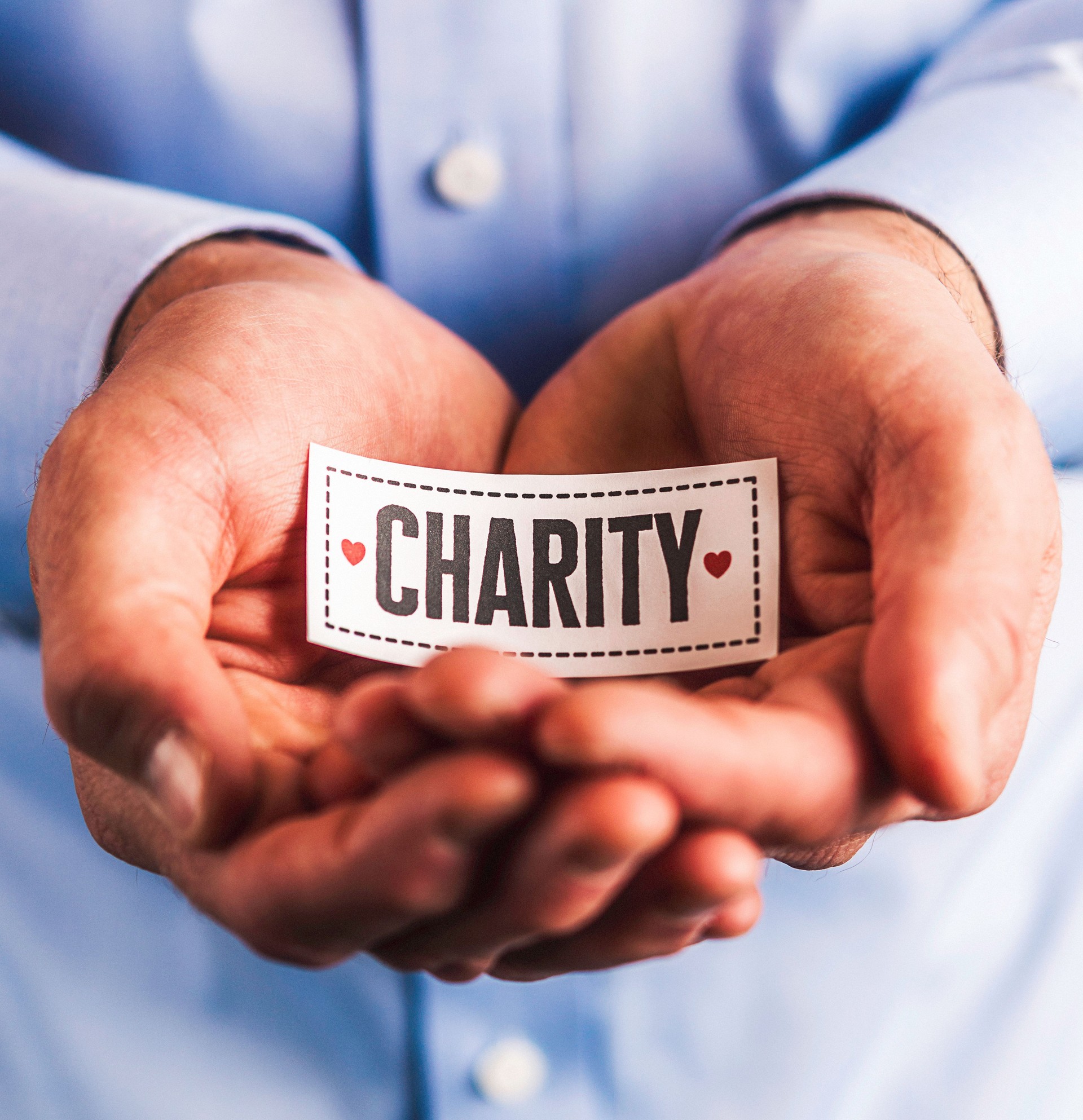 Hands holding charity sign symbolizing nonprofit state registration and renewal services