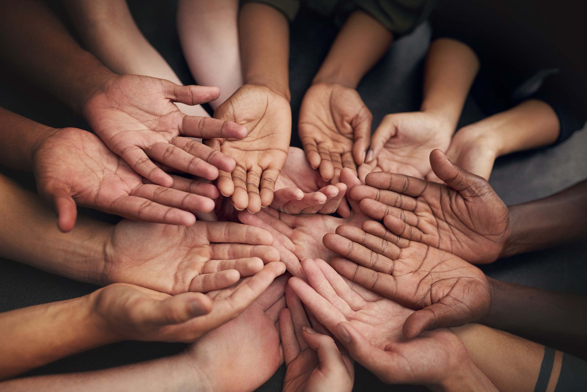 Diverse group of hands symbolizing unity and support for nonprofit organizations of all sizes